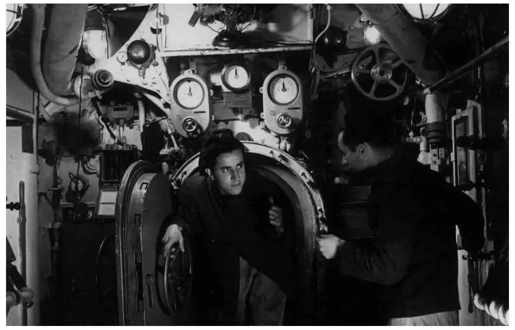 An Italian submarine crew member enters through a watertight door in this 1941 photograph. Image: Archivio Centrale dello Stato