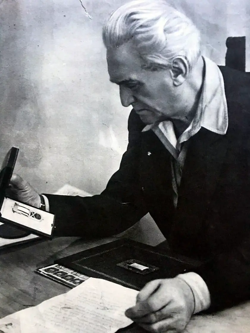 Graziani is seen here in his later years as he looks at a war medal. 