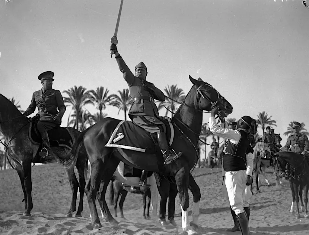 Il Duce on an Arabian horse in Libya, March, 1937. Mussolini is holding the "Sword of Islam" .